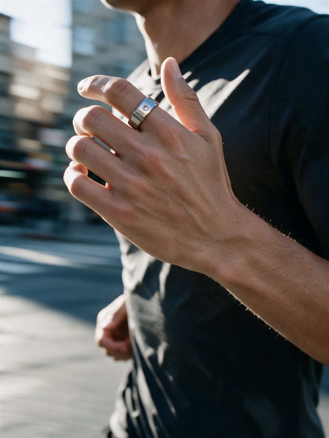 Generated image: close on a man's left hand mid-stride as he runs down a city street at sunrise, the ring on his index finger beside the thumb, the street soft with speed behind