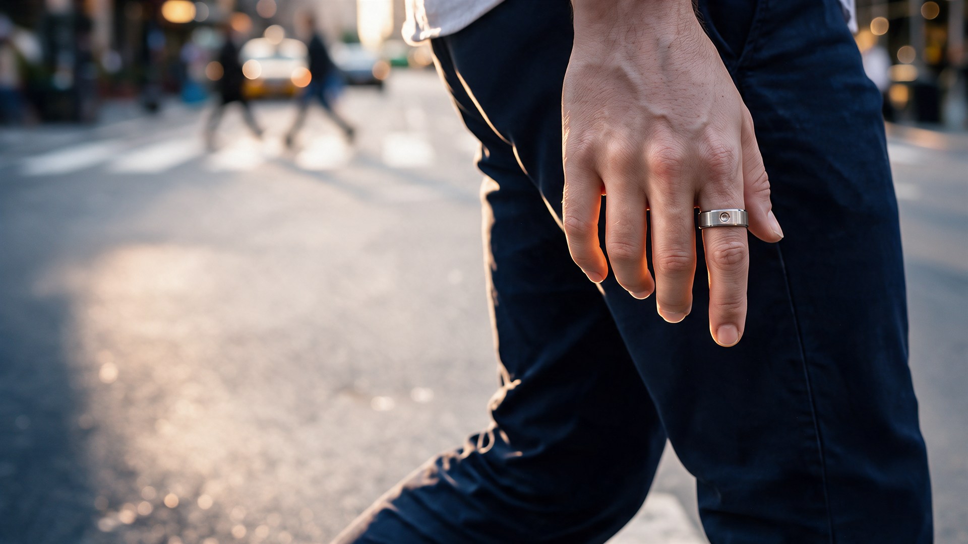 Generated image: a man's right hand mid-stride on a New York avenue in late sun, the ring on his index finger beside the thumb, the street and people crossing soft behind